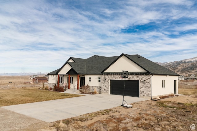 view of front facade with a mountain view, a garage, and a front yard