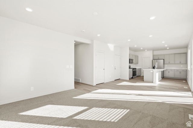 1367 N Harper Way Unit 0248, Tooele, UT 84074 - unfurnished living room with recessed lighting and light carpet
