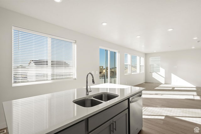 1367 N Harper Way Unit 0248, Tooele, UT 84074 - kitchen with stainless steel dishwasher, open floor plan, wood finished floors, light countertops, and recessed lighting