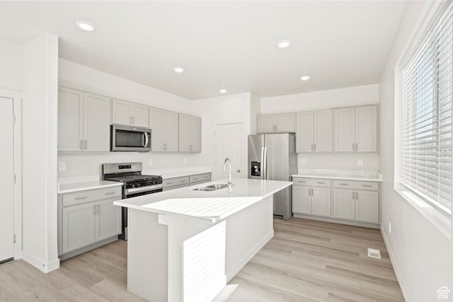 1367 N Harper Way Unit 0248, Tooele, UT 84074 - kitchen with appliances with stainless steel finishes, plenty of natural light, light wood finished floors, a center island with sink, and recessed lighting