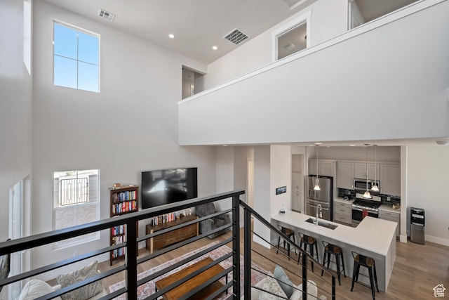 5629 S Adobe Sun Dr, St George, UT 84790 - stairs with sink, a high ceiling, and hardwood / wood-style flooring