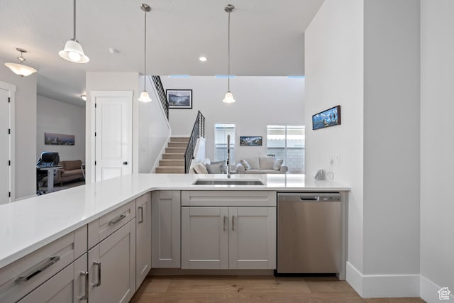 5629 S Adobe Sun Dr, St George, UT 84790 - kitchen featuring dishwasher, sink, hanging light fixtures, light wood-type flooring, and kitchen peninsula