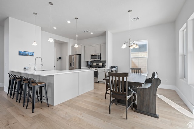 5629 S Adobe Sun Dr, St George, UT 84790 - kitchen with hanging light fixtures, stainless steel appliances, a notable chandelier, kitchen peninsula, and decorative backsplash