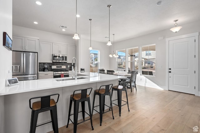 5629 S Adobe Sun Dr, St George, UT 84790 - kitchen with a breakfast bar area, a spacious island, pendant lighting, and appliances with stainless steel finishes