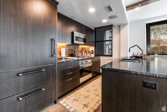 692 Main St Unit D, Park City, UT 84060 - kitchen featuring appliances with stainless steel finishes, dark brown cabinets, dark stone countertops, and sink