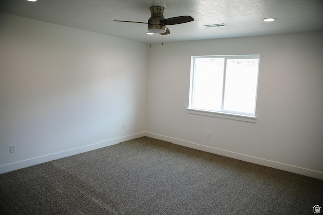 carpeted spare room with ceiling fan