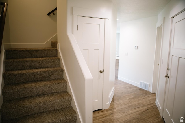 staircase with wood-type flooring
