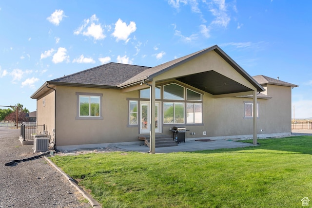 back of property with a lawn, central AC, and a patio