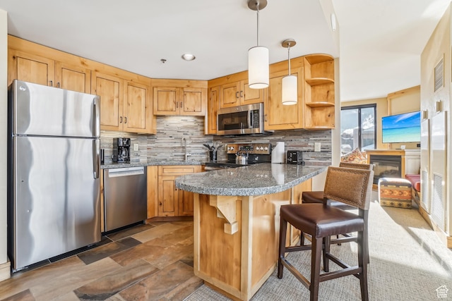 3855 Grand Summit Dr Unit 301, Park City, UT 84098 - kitchen featuring tasteful backsplash, kitchen peninsula, decorative light fixtures, a breakfast bar area, and appliances with stainless steel finishes