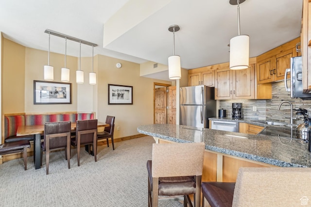 3855 Grand Summit Dr Unit 301, Park City, UT 84098 - kitchen featuring kitchen peninsula, decorative backsplash, stainless steel appliances, sink, and decorative light fixtures