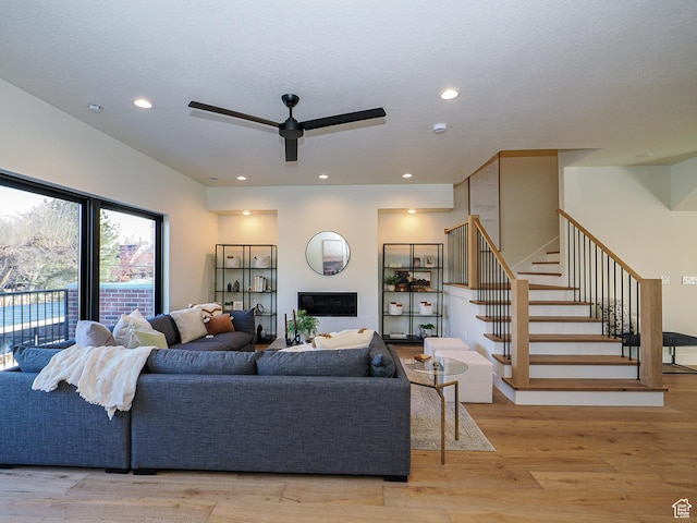 living room with recessed lighting, stairway, light wood-style flooring, and a ceiling fan
