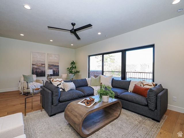 living area with baseboards, a ceiling fan, and recessed lighting
