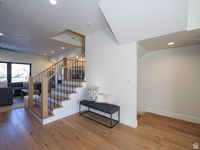 stairway with baseboards, recessed lighting, and hardwood / wood-style floors