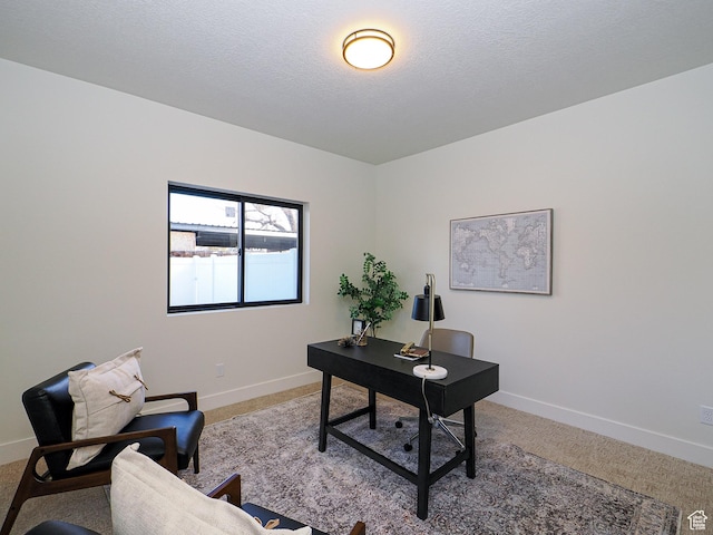 office space featuring a textured ceiling, carpet flooring, and baseboards