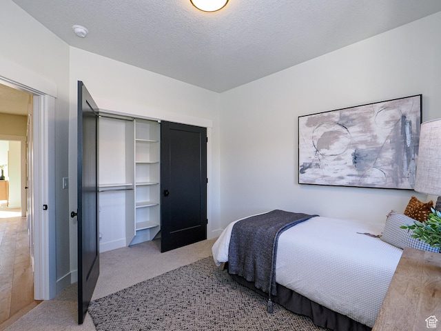carpeted bedroom with a closet and baseboards