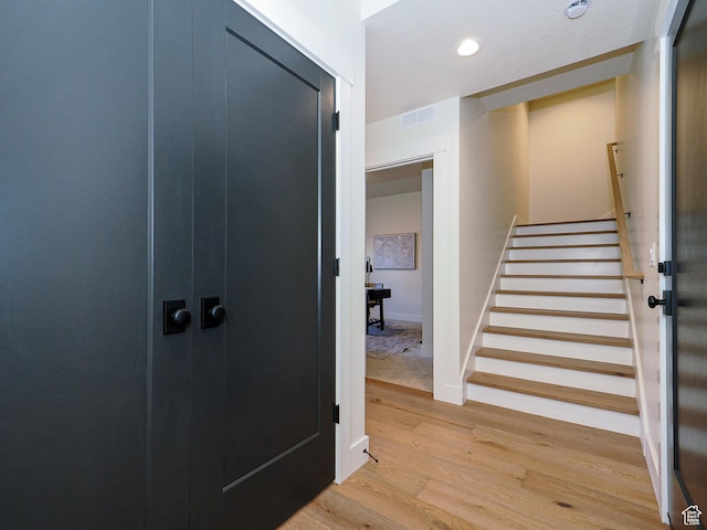 stairway featuring visible vents, baseboards, recessed lighting, and wood finished floors