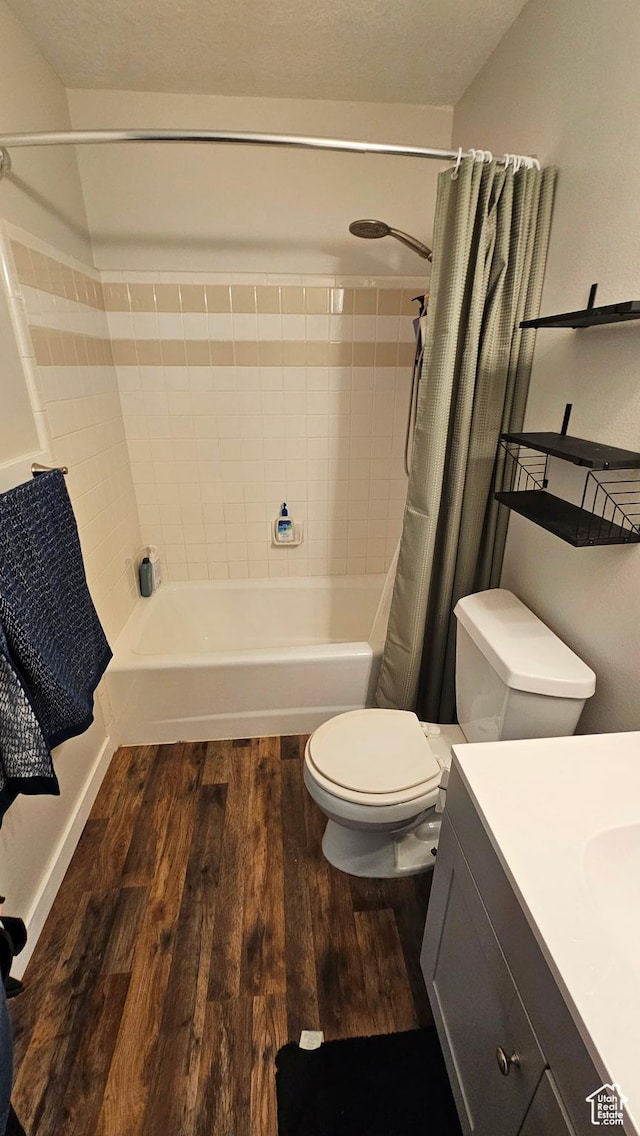 full bathroom with hardwood / wood-style floors, vanity, toilet, and shower / tub combo with curtain