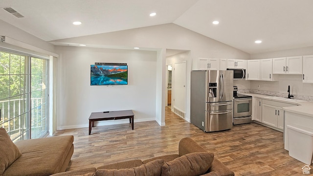 1303 N Riverside Ave Unit 36, Provo, UT 84604 - kitchen with appliances with stainless steel finishes, lofted ceiling, light countertops, light wood-style floors, and white cabinets