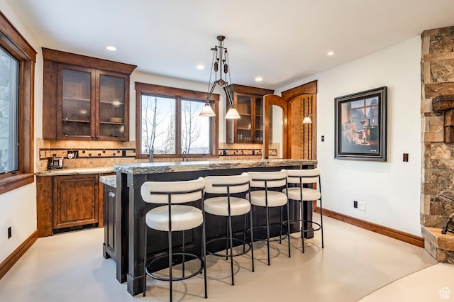 26 White Pine Canyon Rd, Park City, UT 84060 - kitchen featuring decorative backsplash, a breakfast bar, decorative light fixtures, and a kitchen island