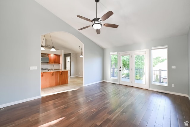 3568 N 500 E, North Ogden, UT 84414 - unfurnished living room with a ceiling fan, wood finished floors, lofted ceiling, baseboards, and arched walkways