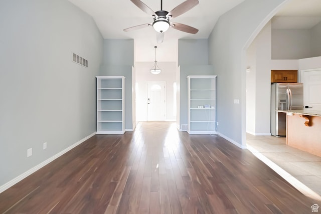 3568 N 500 E, North Ogden, UT 84414 - unfurnished living room featuring arched walkways, high vaulted ceiling, ceiling fan, dark wood finished floors, and baseboards