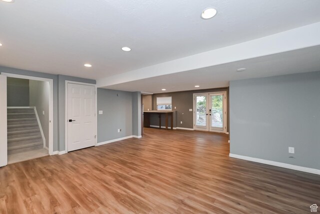 3568 N 500 E, North Ogden, UT 84414 - unfurnished living room with wood finished floors, baseboards, stairway, recessed lighting, and french doors