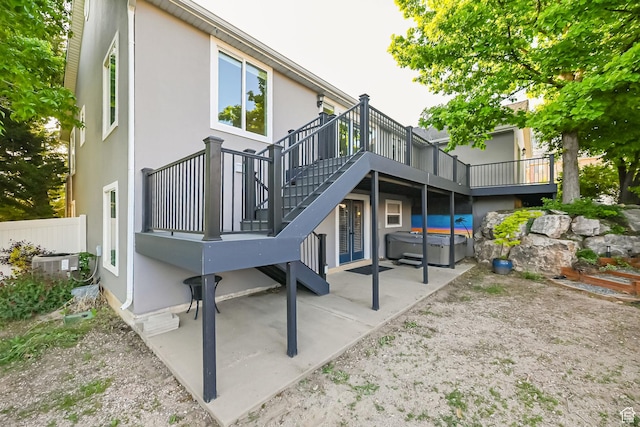 3568 N 500 E, North Ogden, UT 84414 - back of property featuring a hot tub, a patio area, a deck, stucco siding, and central AC