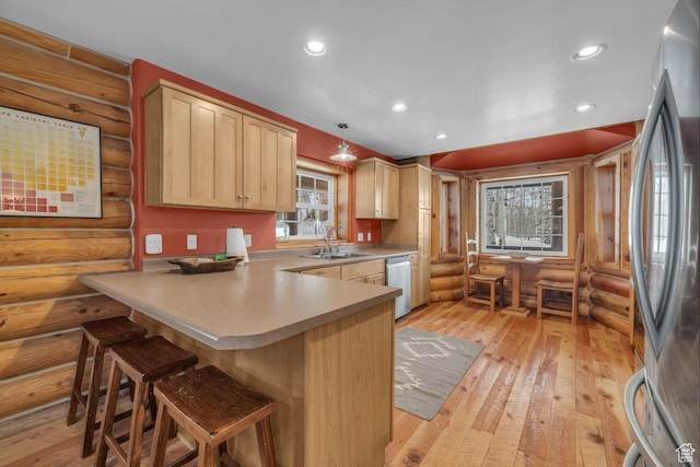 4125 S Buck Way Unit 1958, Heber City, UT 84032 - kitchen featuring light brown cabinets, hanging light fixtures, log walls, a breakfast bar area, and stainless steel appliances