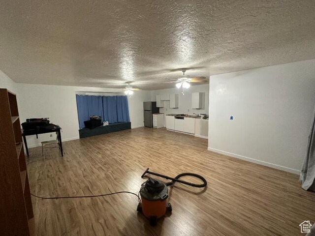unfurnished living room with wood-type flooring and a textured ceiling
