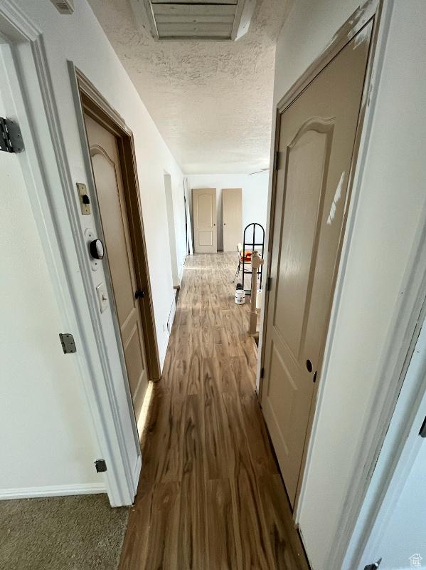 hallway featuring dark hardwood / wood-style flooring and a textured ceiling