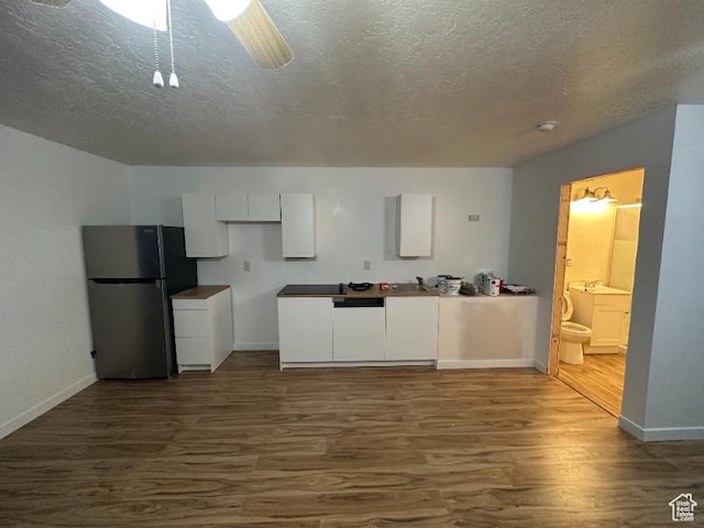 kitchen with stainless steel fridge, dark hardwood / wood-style flooring, white cabinetry, and sink