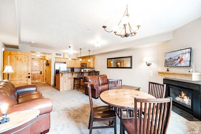 carpeted dining area featuring an inviting chandelier