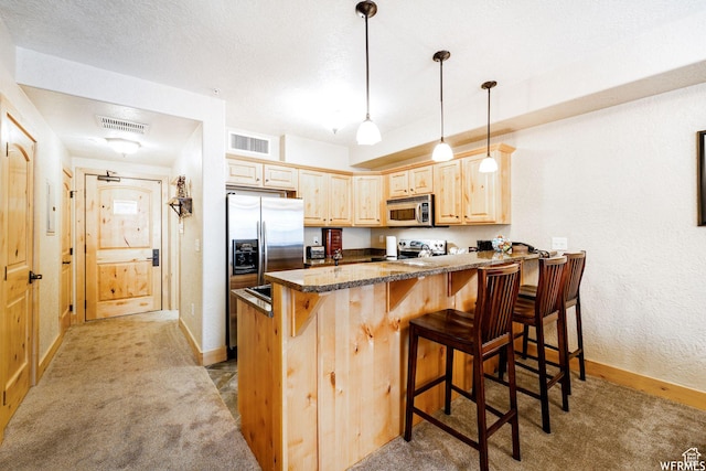 2653 Canyon Resort Dr Unit 227, Park City, UT 84098 - kitchen with light brown cabinets, stainless steel appliances, kitchen peninsula, light colored carpet, and a kitchen bar