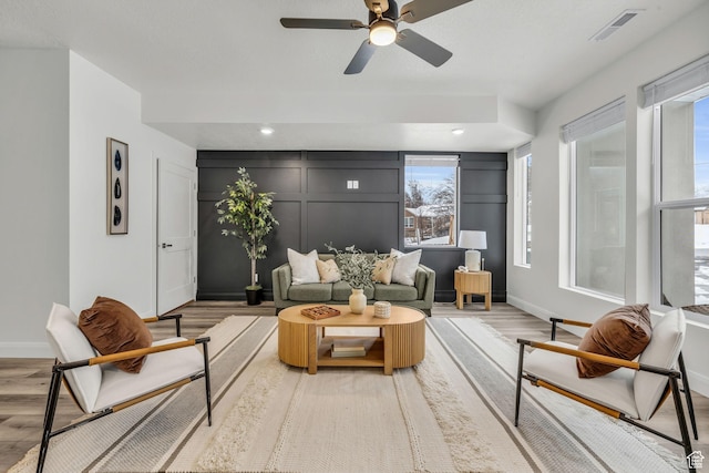 233 E Burch Creek Pl S, Ogden, UT 84405 - living room with light wood-type flooring, visible vents, a ceiling fan, a decorative wall, and baseboards