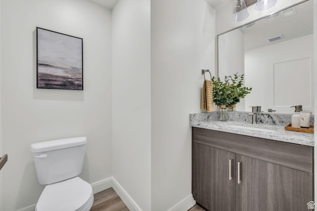 233 E Burch Creek Pl S, Ogden, UT 84405 - bathroom featuring vanity, wood finished floors, visible vents, baseboards, and toilet