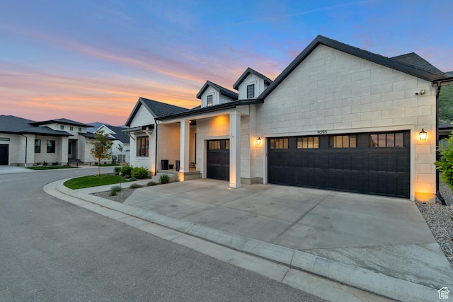 view of front of house featuring concrete driveway, concrete block siding, an attached garage, and a shingled roof