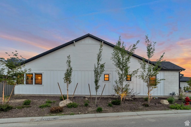 property exterior at dusk featuring board and batten siding