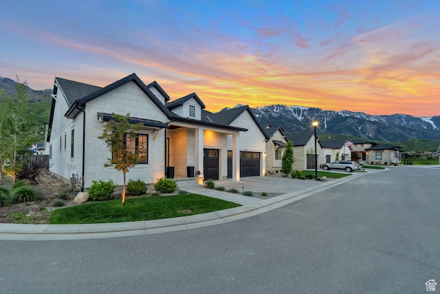 view of front of property featuring concrete driveway, concrete block siding, a mountain view, and an attached garage