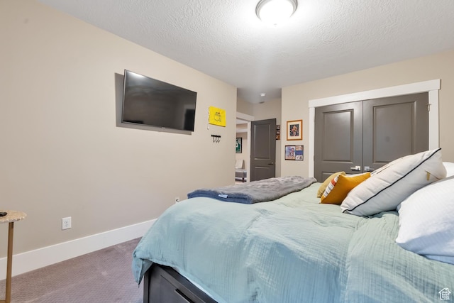 carpeted bedroom featuring a closet and baseboards