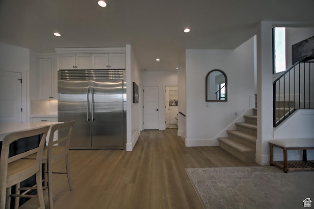 585 N Amber Ln, Garden City, UT 84028 - kitchen featuring white cabinets, stainless steel built in fridge, and light hardwood / wood-style flooring