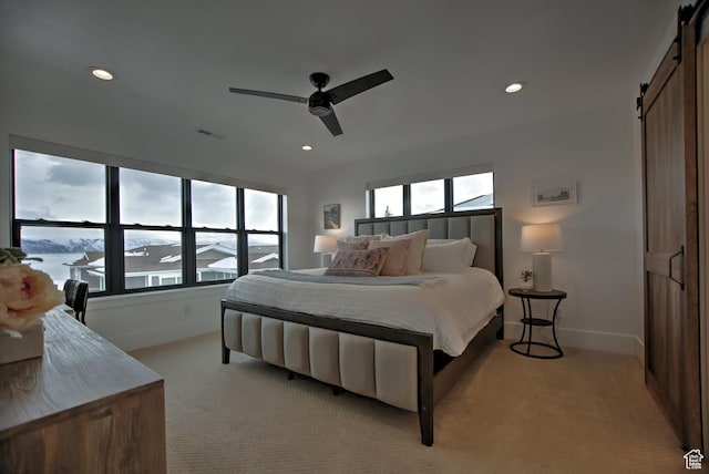 585 N Amber Ln, Garden City, UT 84028 - bedroom featuring a barn door, light colored carpet, and ceiling fan