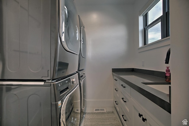 585 N Amber Ln, Garden City, UT 84028 - washroom with stacked washer and dryer, cabinets, and tile patterned flooring