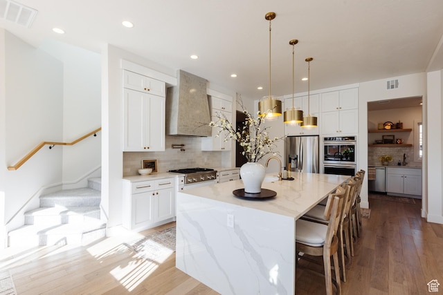 3305 W 2610 S, Hurricane, UT 84737 - kitchen with light wood-style floors, stainless steel appliances, decorative backsplash, and visible vents