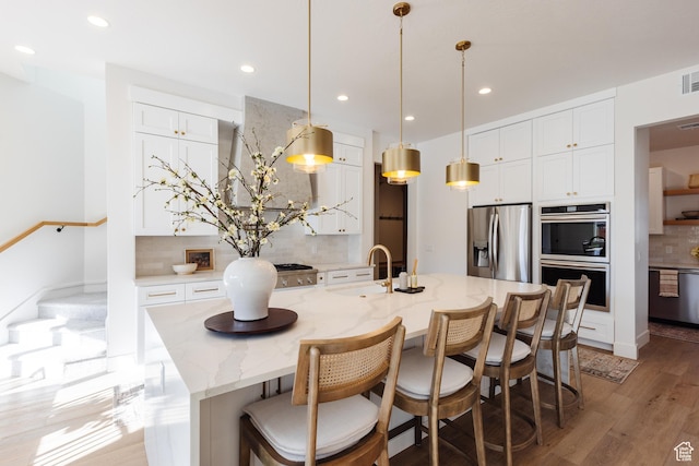 3305 W 2610 S, Hurricane, UT 84737 - kitchen with a sink, stainless steel appliances, white cabinetry, light wood-style floors, and tasteful backsplash
