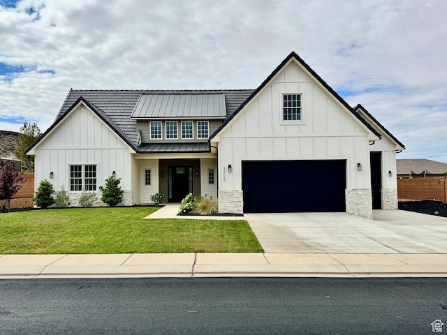 modern inspired farmhouse featuring a front yard, an attached garage, stone siding, and board and batten siding