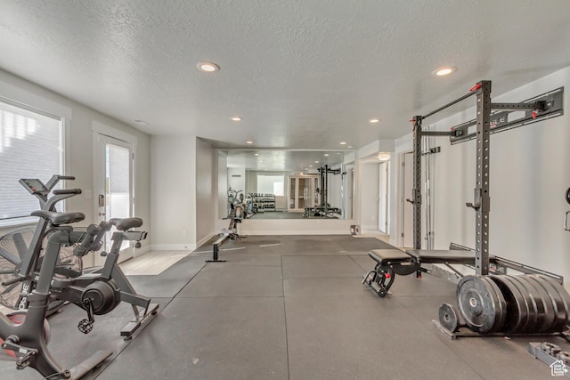 exercise room with baseboards, recessed lighting, and a textured ceiling