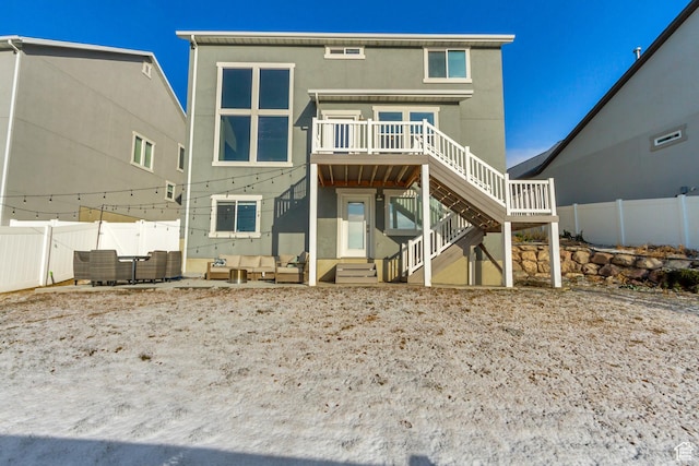 back of house featuring outdoor lounge area, fence, a wooden deck, stucco siding, and stairway
