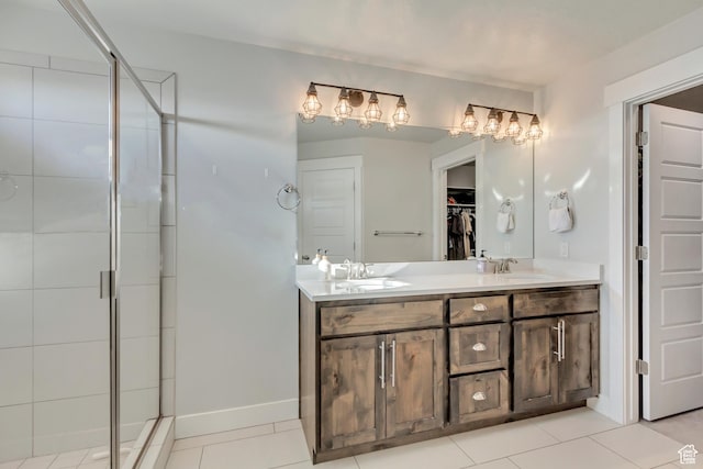 bathroom featuring tile patterned flooring, double vanity, a sink, and a shower stall