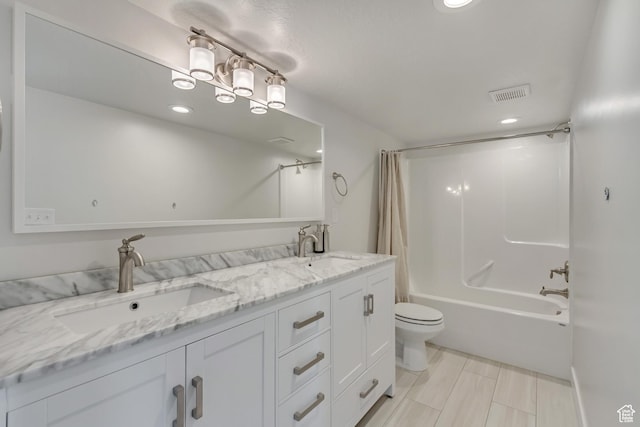 full bathroom with a sink, toilet, double vanity, and visible vents