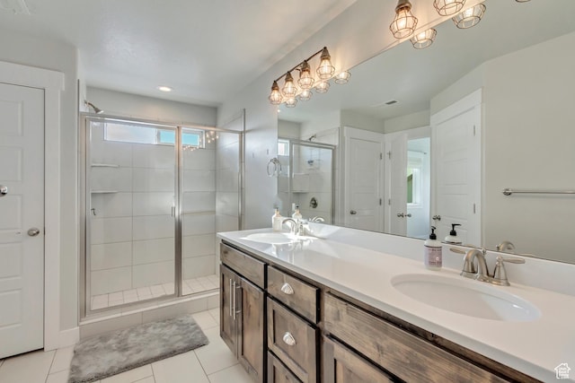 full bath with a sink, tile patterned floors, a shower stall, and double vanity
